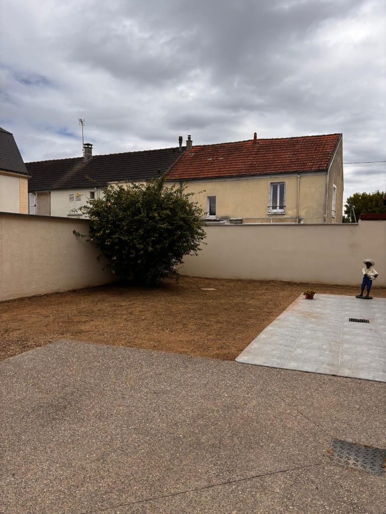 Avant : zone en terre nue entre cour en gravier et patio carrelé